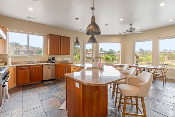Kitchen with stainless steel appliances, stone tile flooring, a sink, healthy amount of natural light, and recessed lighting
