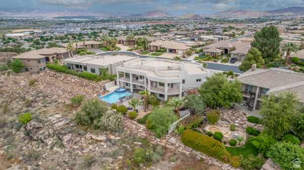 Aerial view of residential area featuring mountains and a pool area