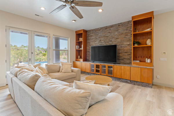 Living area featuring light wood-style flooring, a ceiling fan, built in shelves, french doors, and recessed lighting
