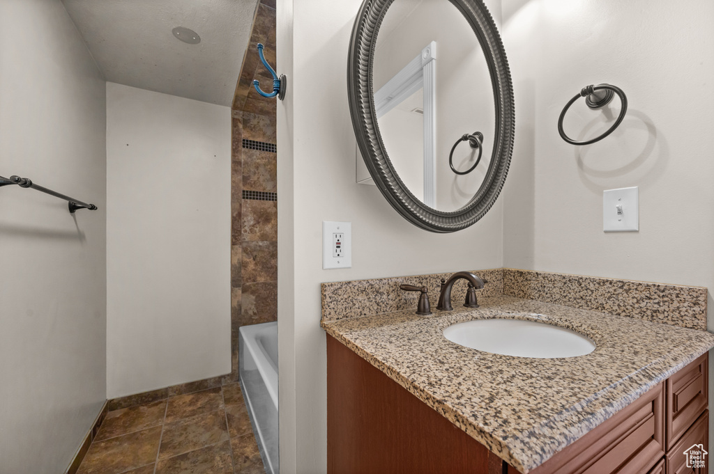 Bathroom with baseboards, vanity, and stone finish floors