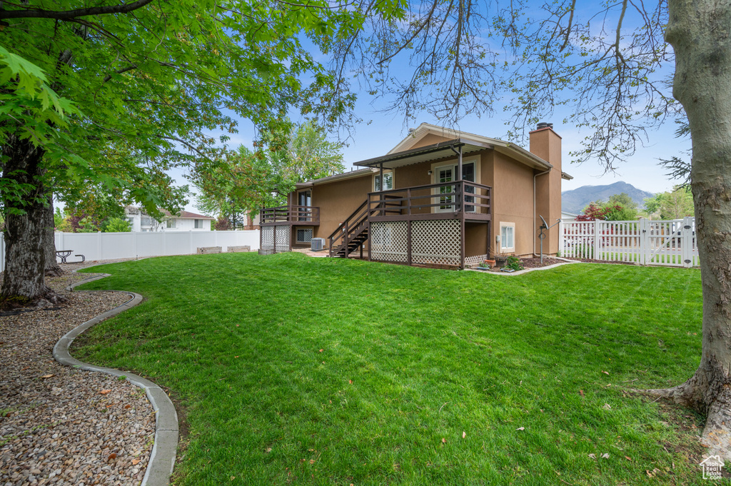 View of yard featuring stairs and a deck with mountain view