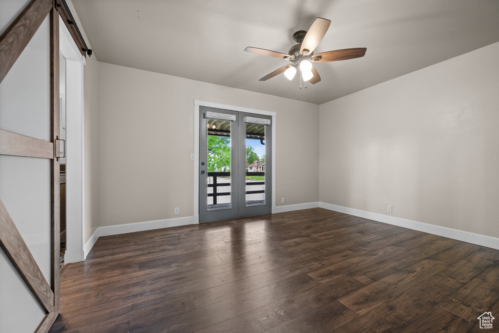 Unfurnished room featuring ceiling fan, wood finished floors, and baseboards