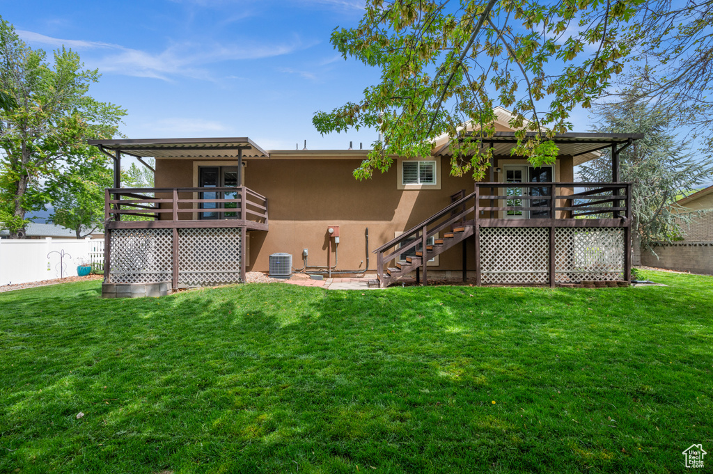 Rear view of property featuring stucco siding, stairway, and a deck