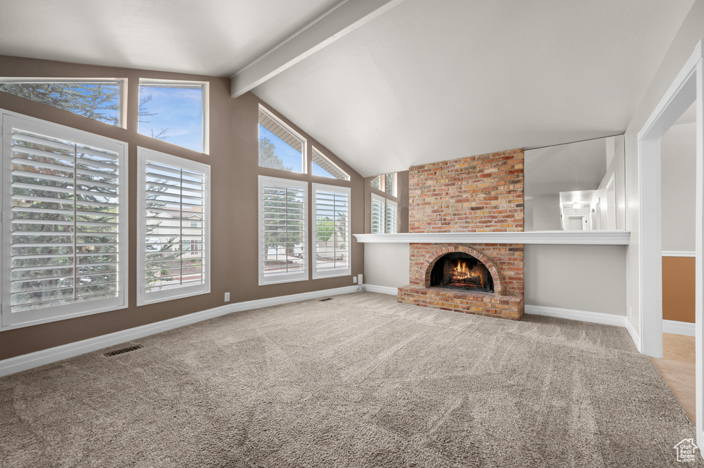 Unfurnished living room with carpet flooring, baseboards, and a brick fireplace