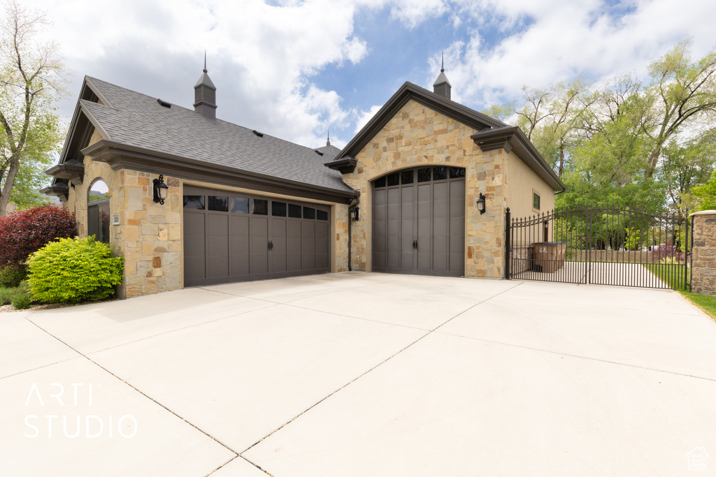 Garage with fence, a gate, and concrete driveway