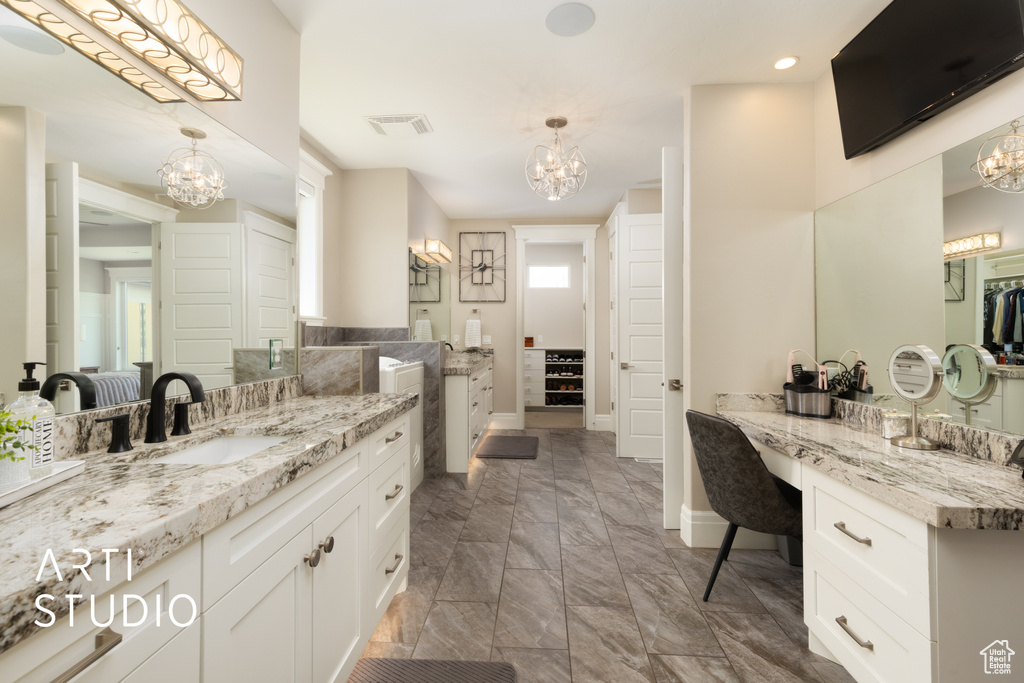 Bathroom featuring a chandelier, baseboards, two vanities, and recessed lighting