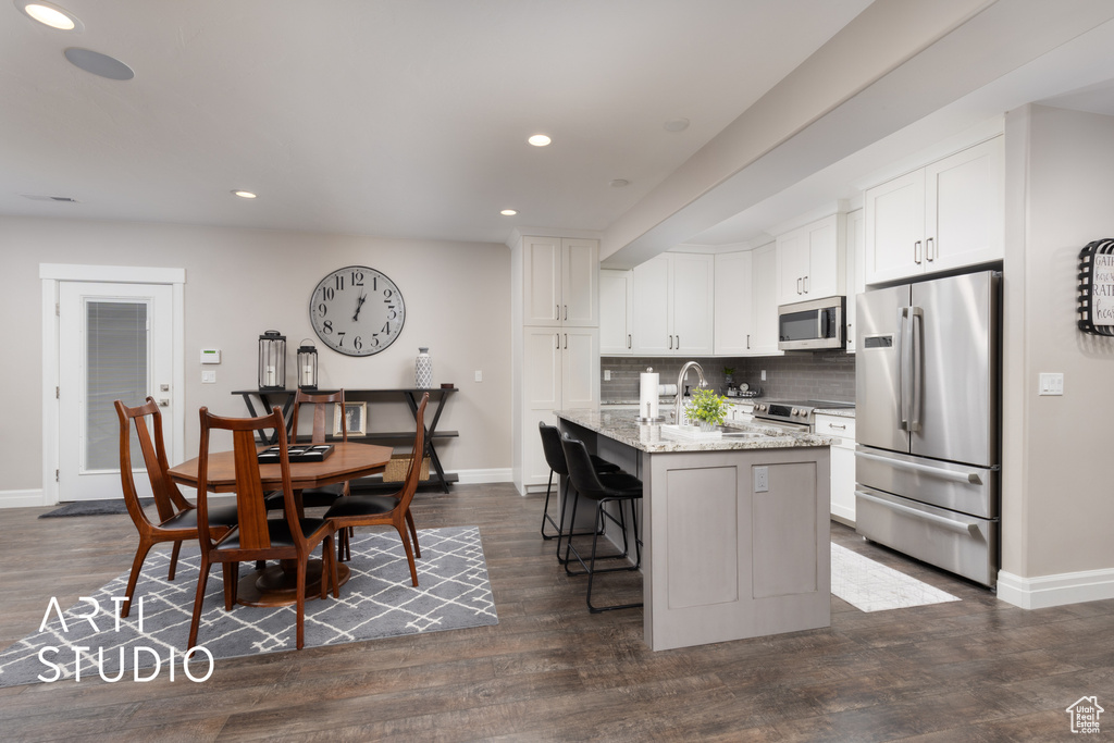 Kitchen featuring stainless steel appliances, baseboards, tasteful backsplash, recessed lighting, and light stone countertops