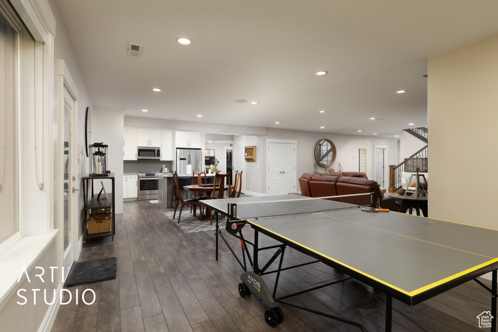 Recreation room with recessed lighting and dark wood-style floors