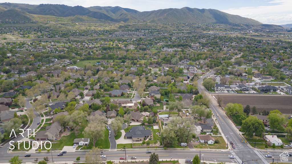 Aerial view of property and surrounding area with mountains and nearby suburban area