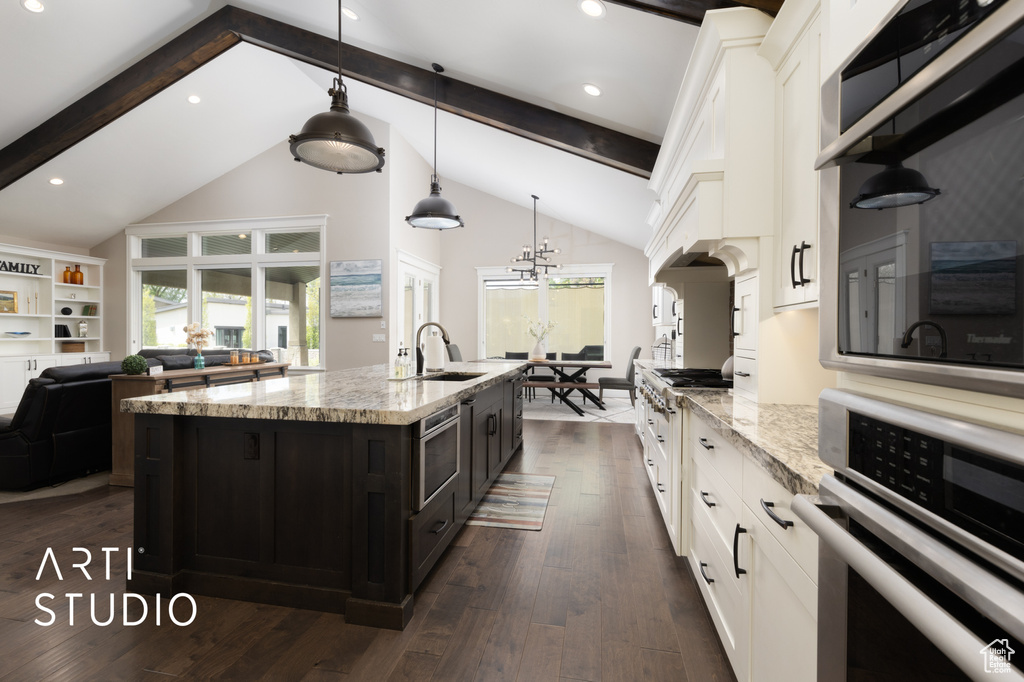 Kitchen featuring oven, a sink, white cabinets, beamed ceiling, and dark wood-style flooring
