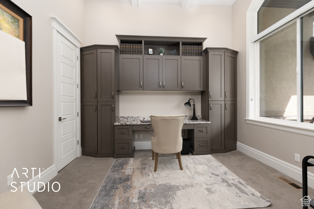 Office space with built in study area, carpet flooring, and baseboards