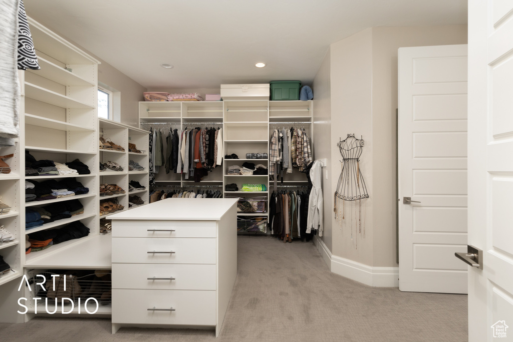 Walk in closet with light colored carpet