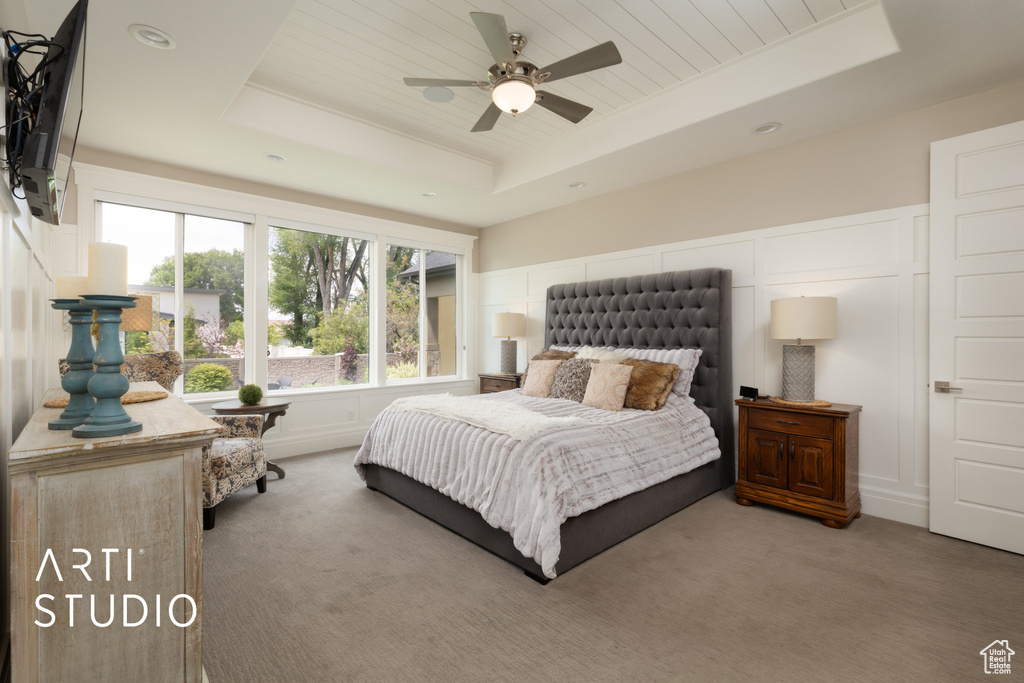 Carpeted bedroom with a raised ceiling and recessed lighting