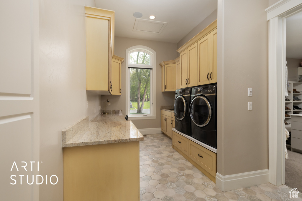Washroom featuring cabinet space, independent washer and dryer, baseboards, and attic access