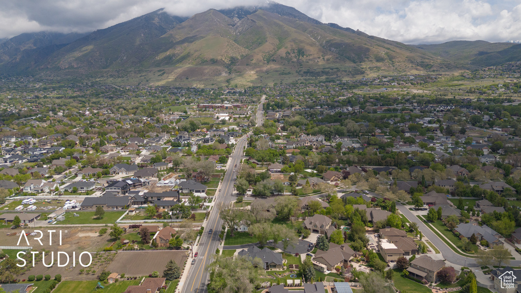 Aerial view of property's location featuring a mountain backdrop and nearby suburban area