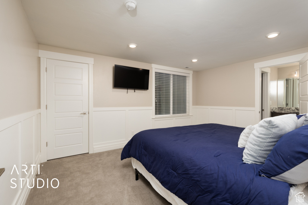 Carpeted bedroom featuring wainscoting, a decorative wall, and recessed lighting