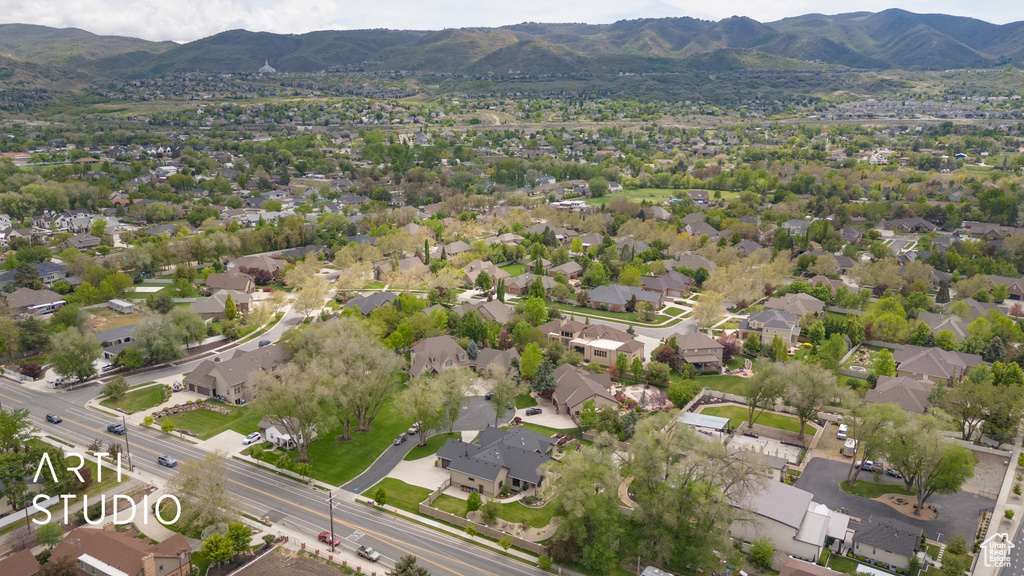 Aerial view of property and surrounding area with mountains and nearby suburban area