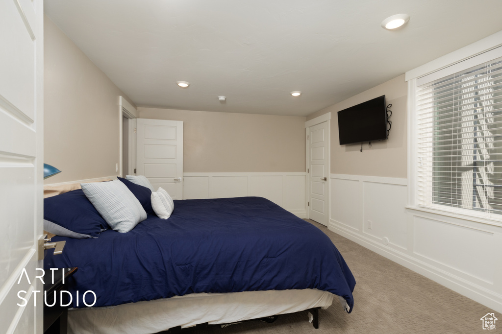 Carpeted bedroom featuring wainscoting and recessed lighting