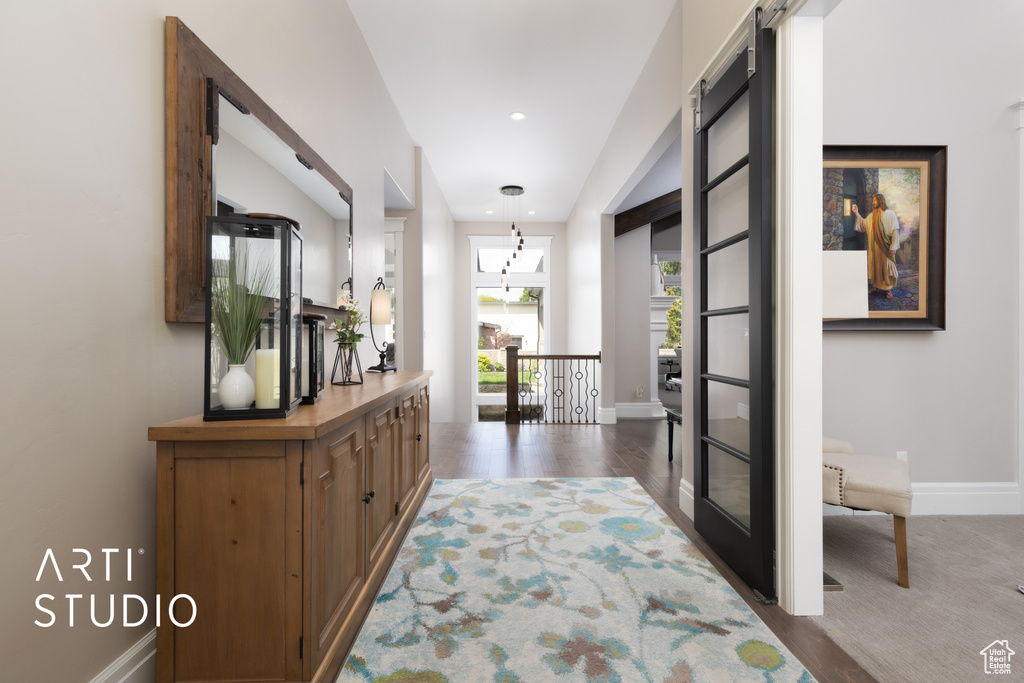 Hall with baseboards, wood finished floors, and an upstairs landing