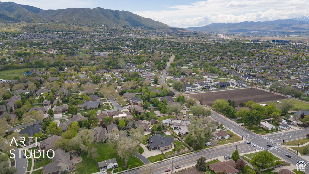 Aerial view of property and surrounding area with mountains and nearby suburban area