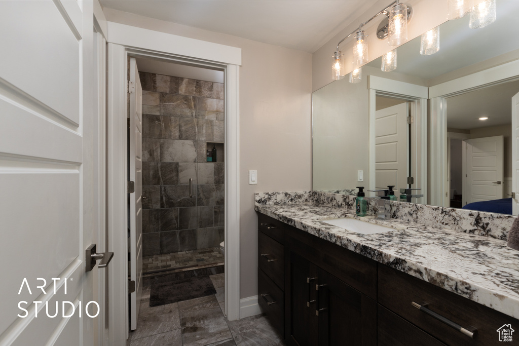Full bathroom with vanity, tiled shower, and toilet