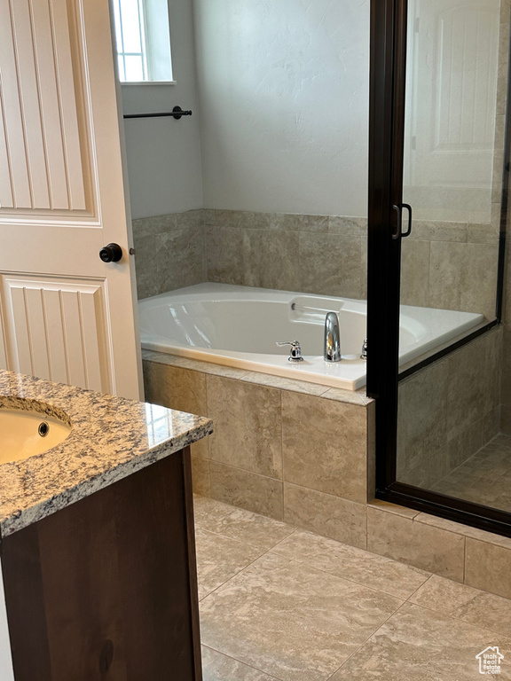 Full bath featuring a bath, vanity, and a shower with shower door