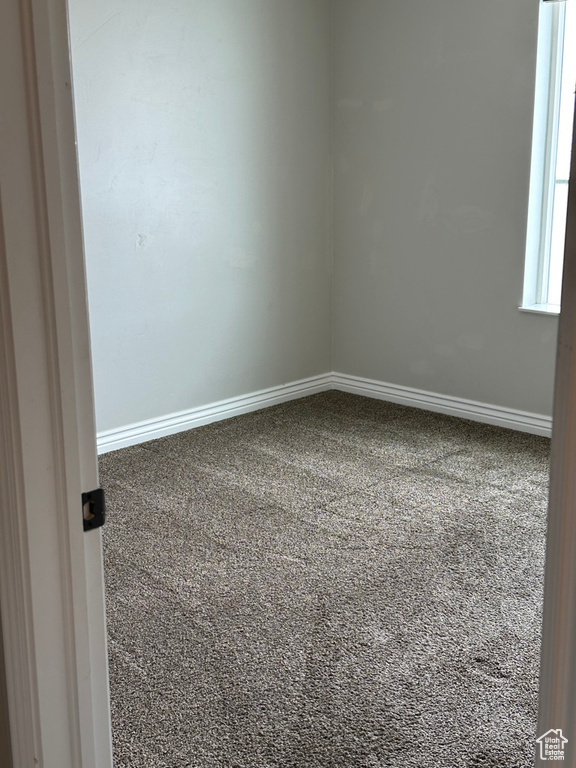Empty room featuring carpet floors and baseboards
