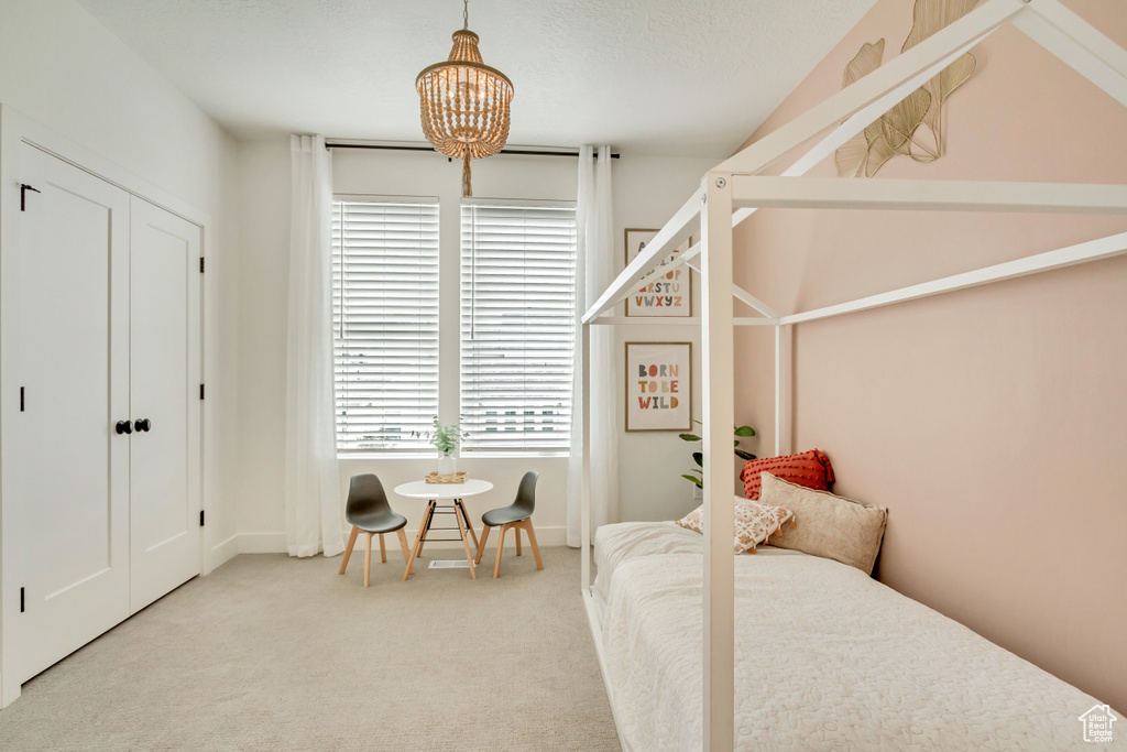 Carpeted bedroom featuring a chandelier