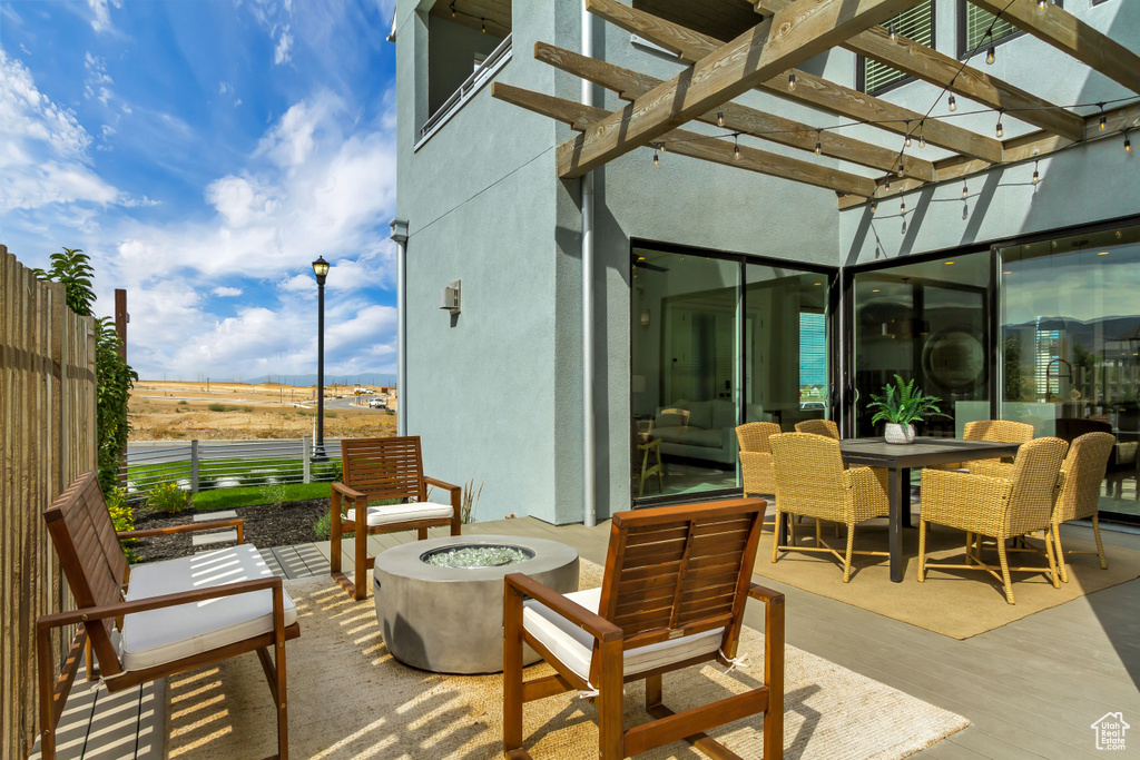 View of patio featuring an outdoor fire pit, a pergola, and outdoor dining area