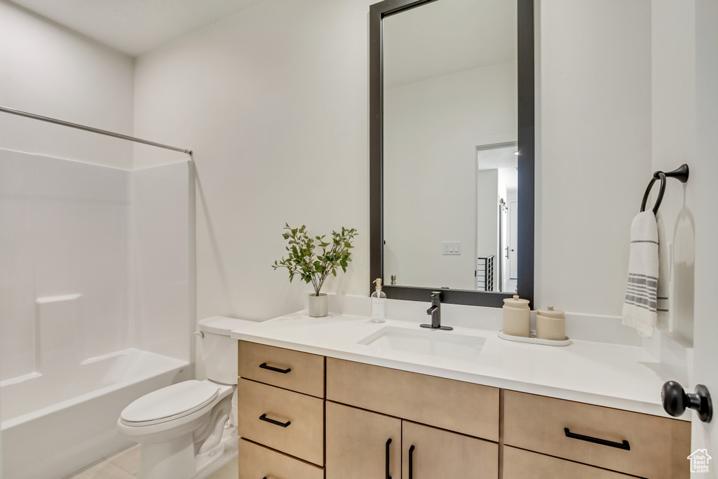 Full bath featuring vanity, toilet, and shower / washtub combination