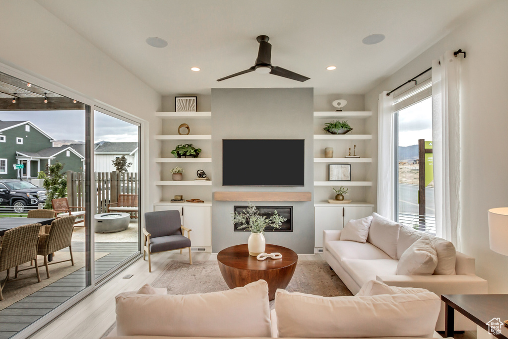 Living area featuring plenty of natural light, light wood-style floors, a ceiling fan, and recessed lighting
