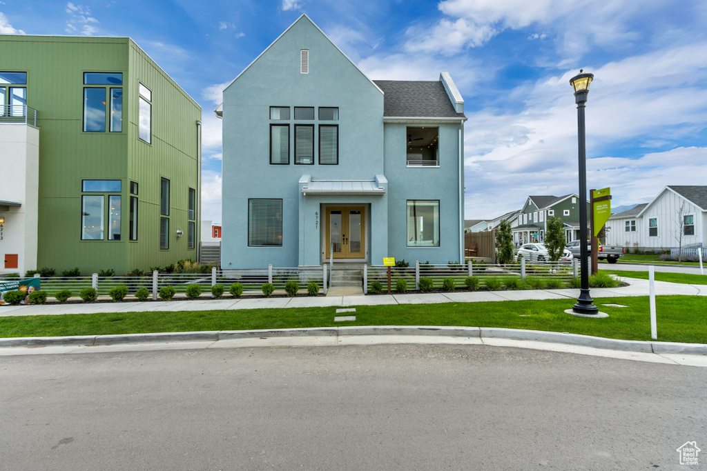 View of front of home with french doors, a fenced front yard, stucco siding, and a residential view