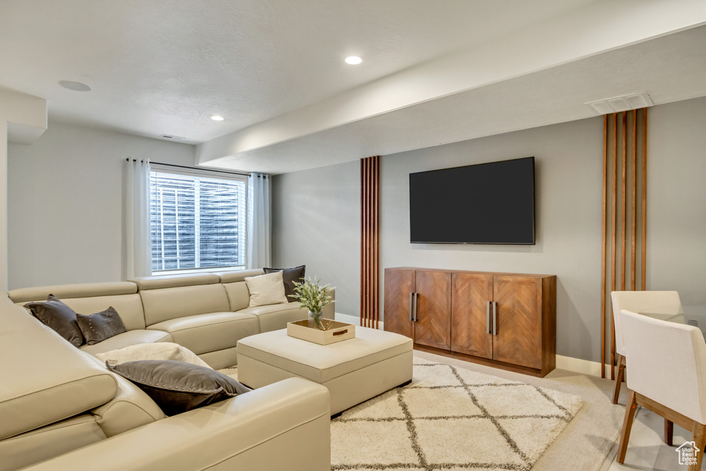 Living room with light carpet, baseboards, and recessed lighting