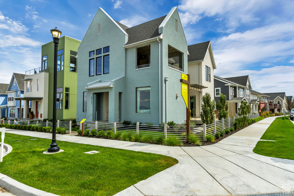 View of front of property with a residential view, stucco siding, and roof with shingles