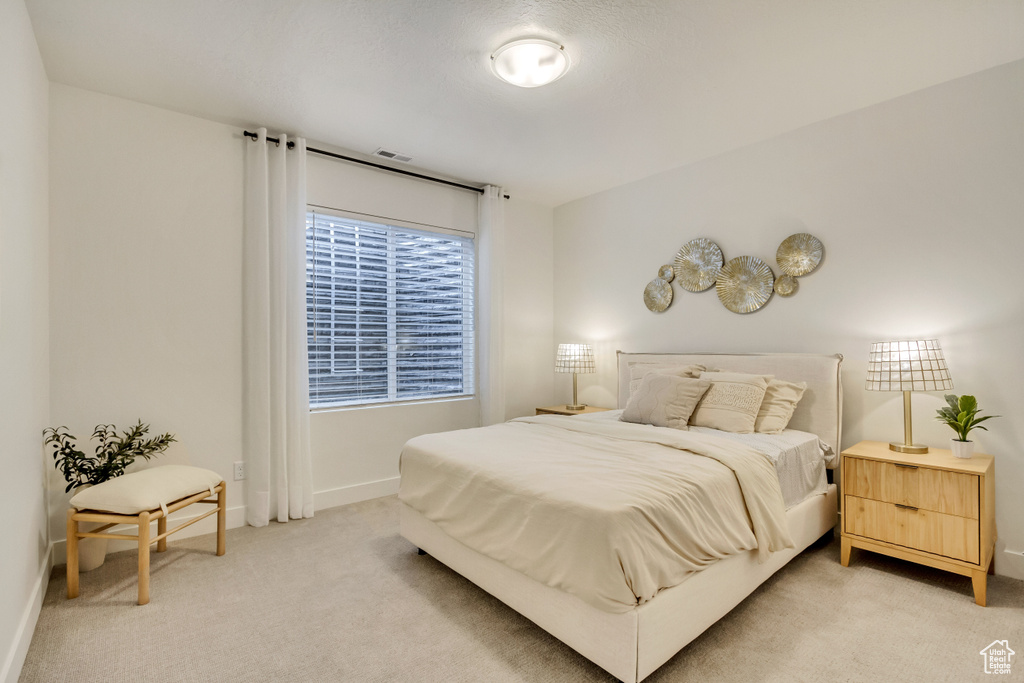 Bedroom with light carpet and baseboards