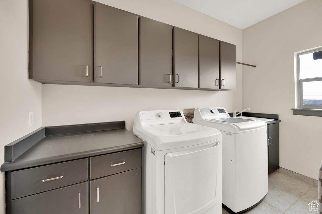 Washroom with cabinet space, separate washer and dryer, and baseboards
