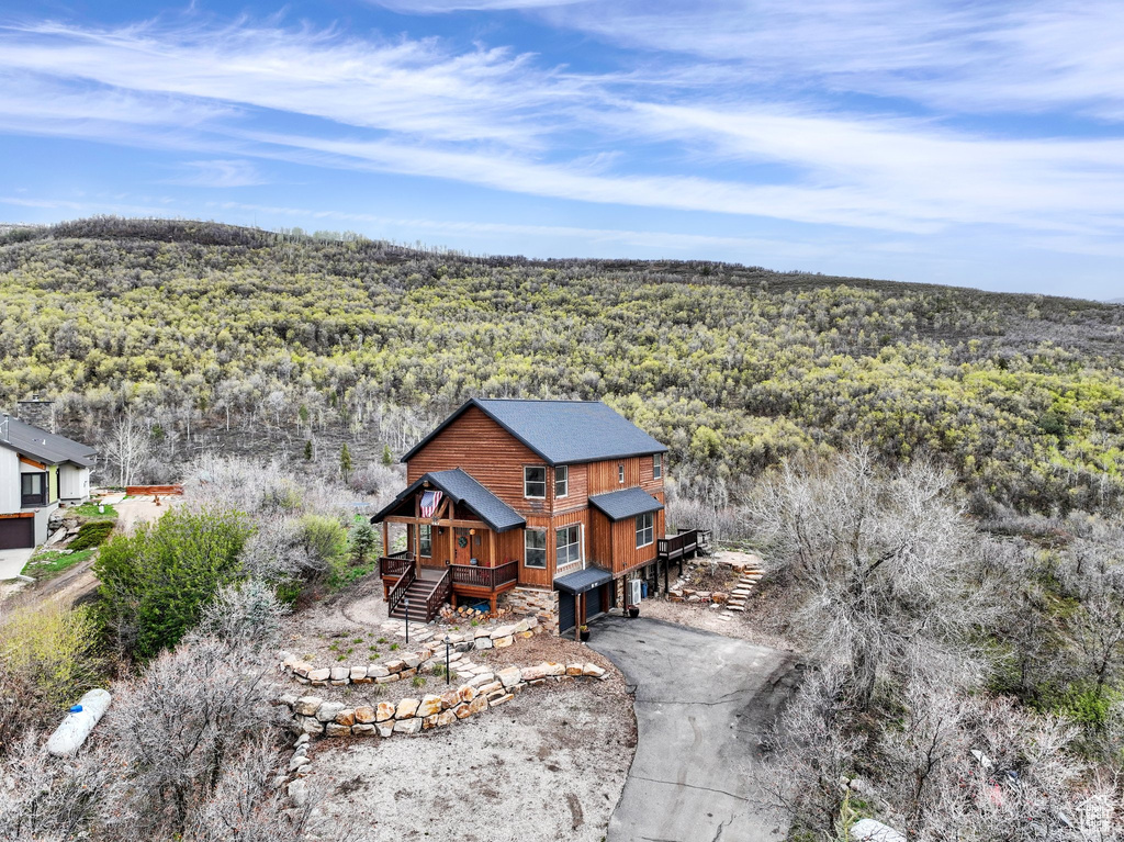Aerial view of property and surrounding area featuring a forest