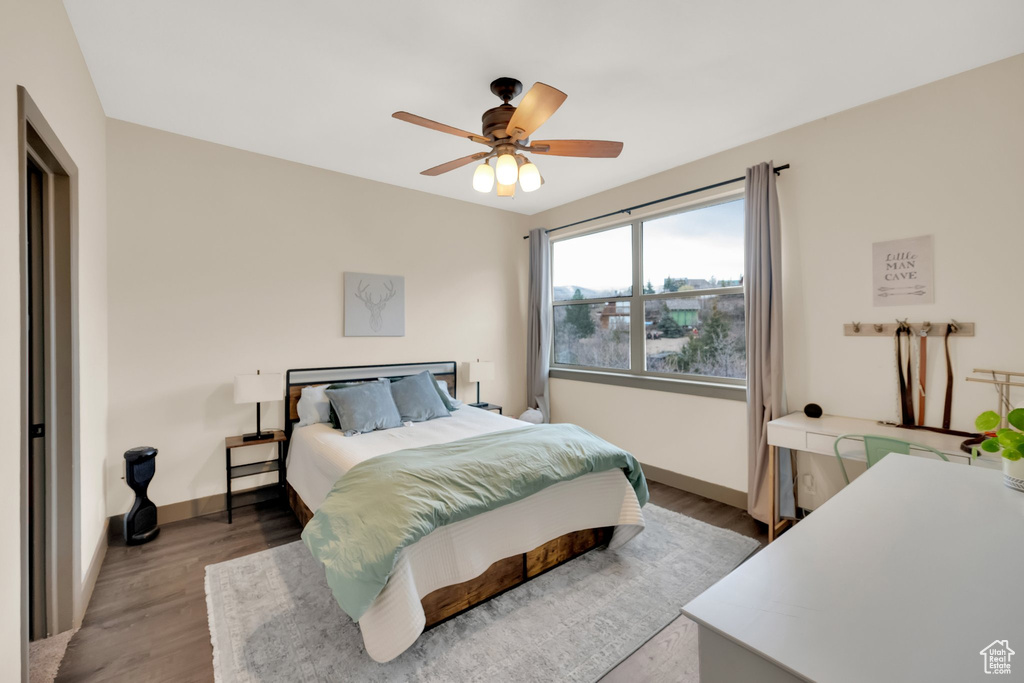 Bedroom with wood finished floors, baseboards, and a ceiling fan