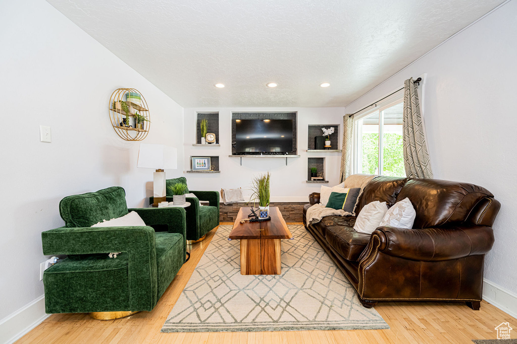 Living area featuring light wood-type flooring, baseboards, and recessed lighting