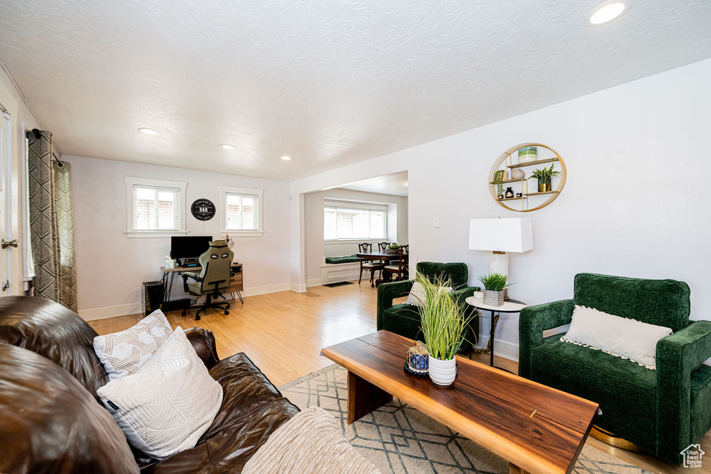 Living room with light wood-style floors, a desk, recessed lighting, and baseboards