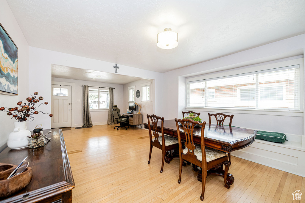 Dining space with light wood-style flooring, an office area, and baseboards