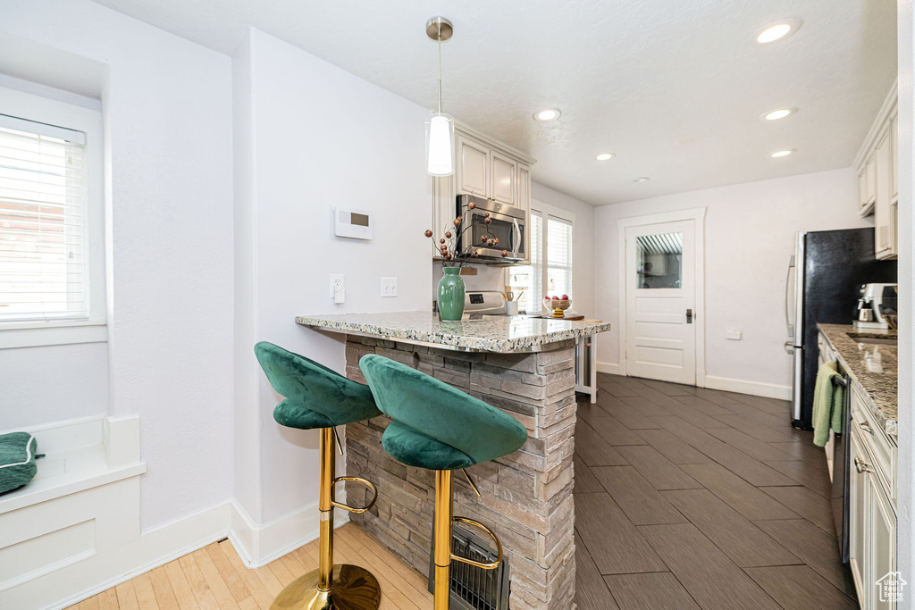 Kitchen featuring appliances with stainless steel finishes, dark wood-style flooring, recessed lighting, baseboards, and light stone countertops