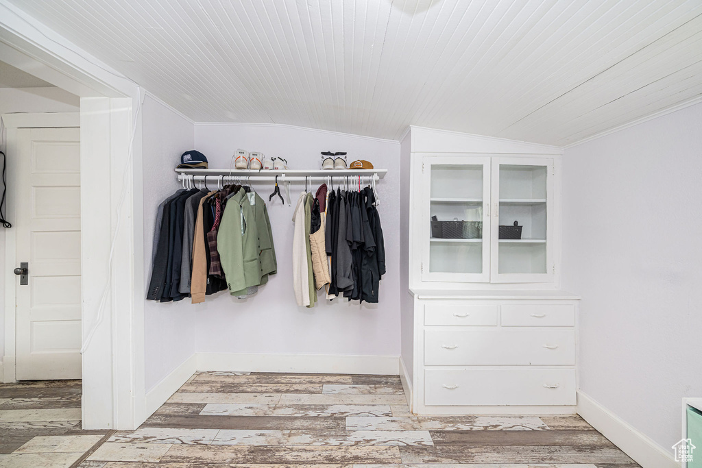 Walk in closet featuring lofted ceiling and light wood-type flooring