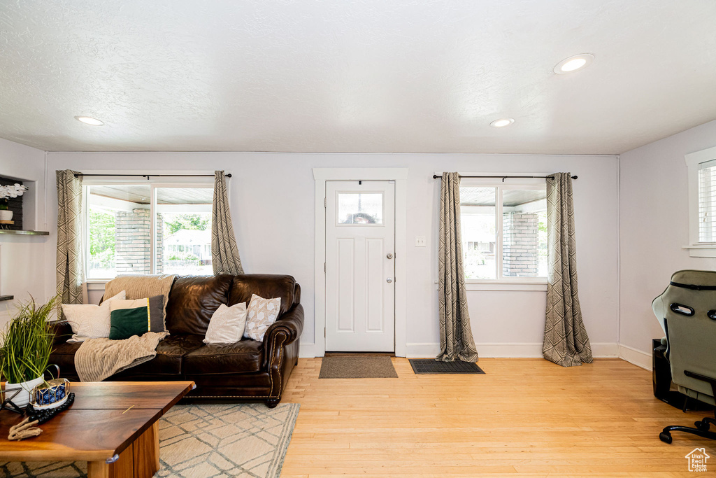 Living room featuring plenty of natural light, light wood finished floors, recessed lighting, and baseboards
