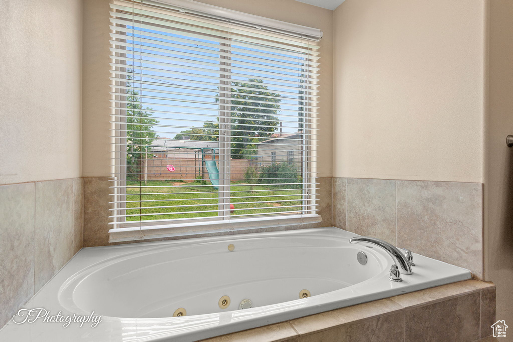 Bathroom featuring plenty of natural light and a tub with jets