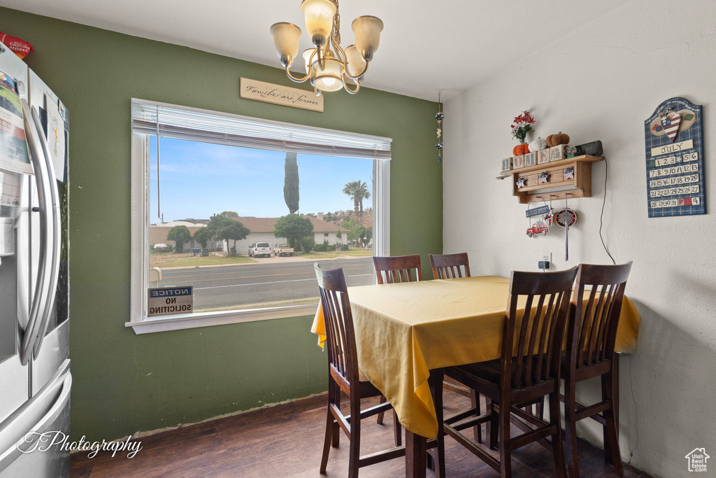 Dining space featuring a chandelier, wood finished floors, and baseboards