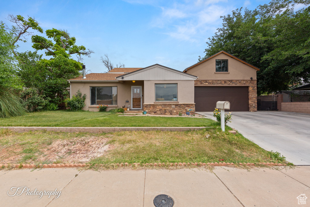 Ranch-style home featuring stucco siding, concrete driveway, stone siding, and a garage