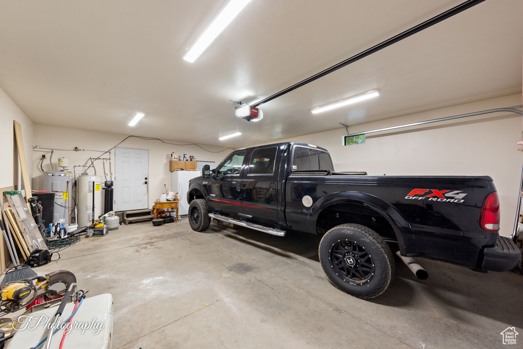 Garage featuring water heater and a garage door opener