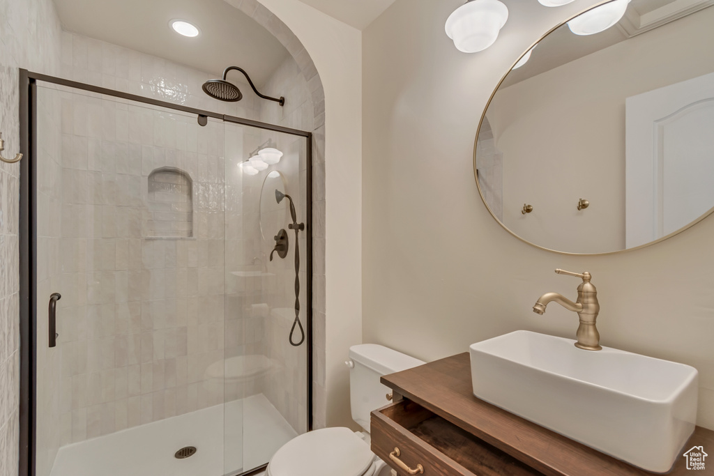 Full bathroom featuring a shower stall, toilet, and vanity