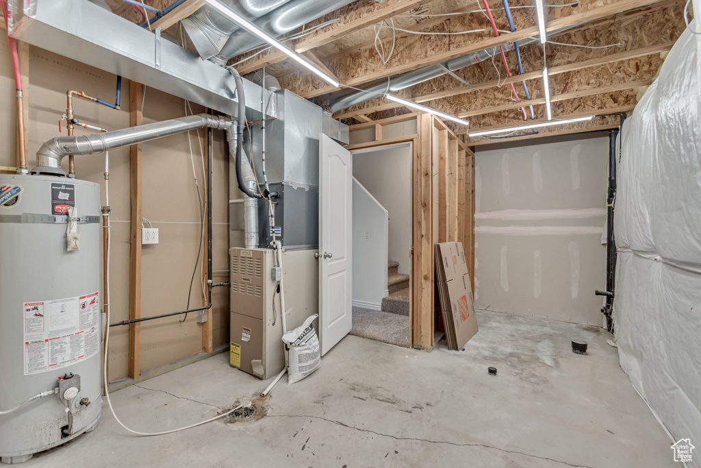 Unfinished below grade area with gas water heater and heating unit